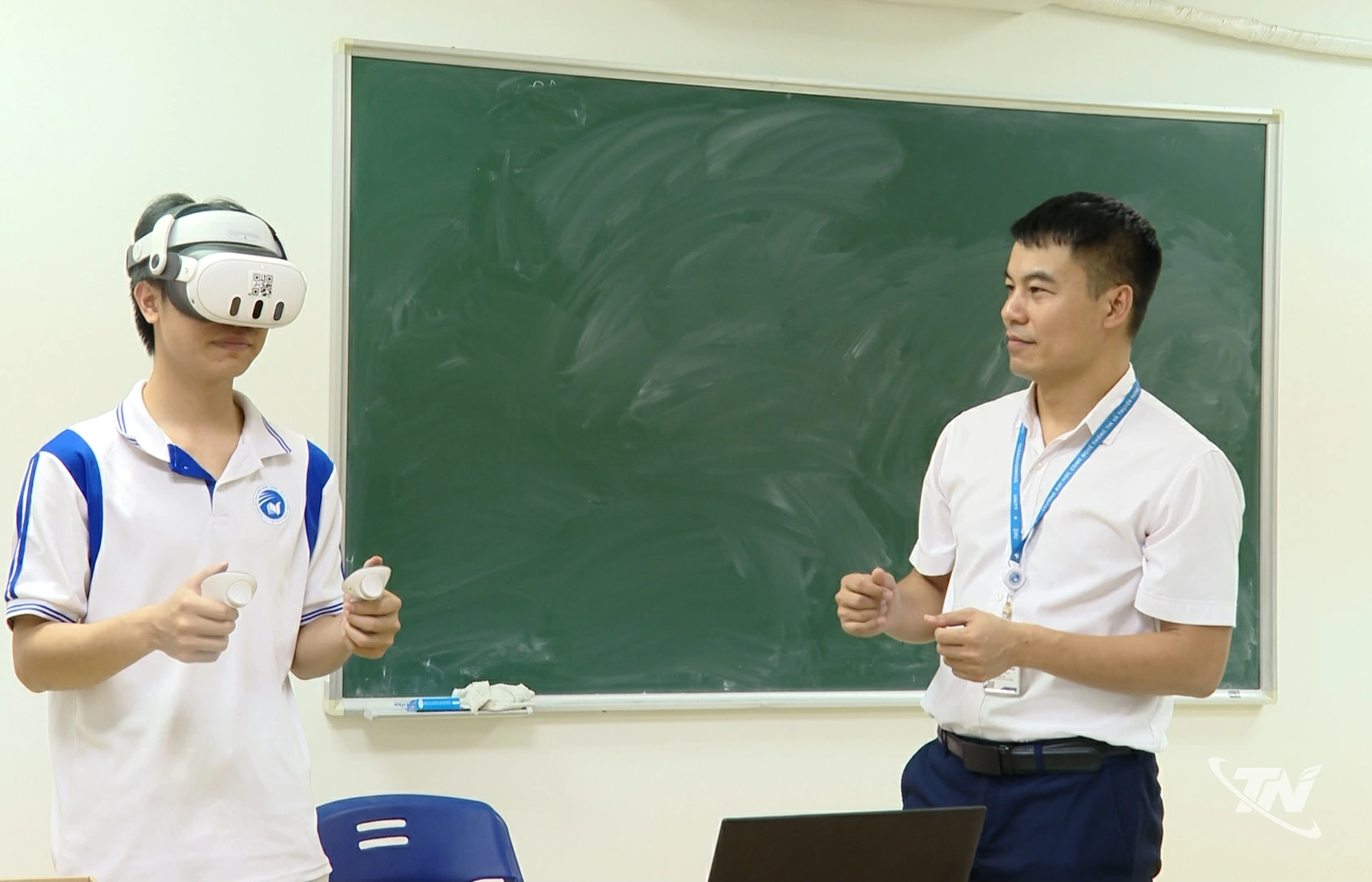 Giảng viên trường Đại học CNTT và Truyền thông hướng dẫn sinh viên trải nghiệm ứng dụng công nghệ thực tế ảo mô phỏng xưởng lắp ráp ô tô.