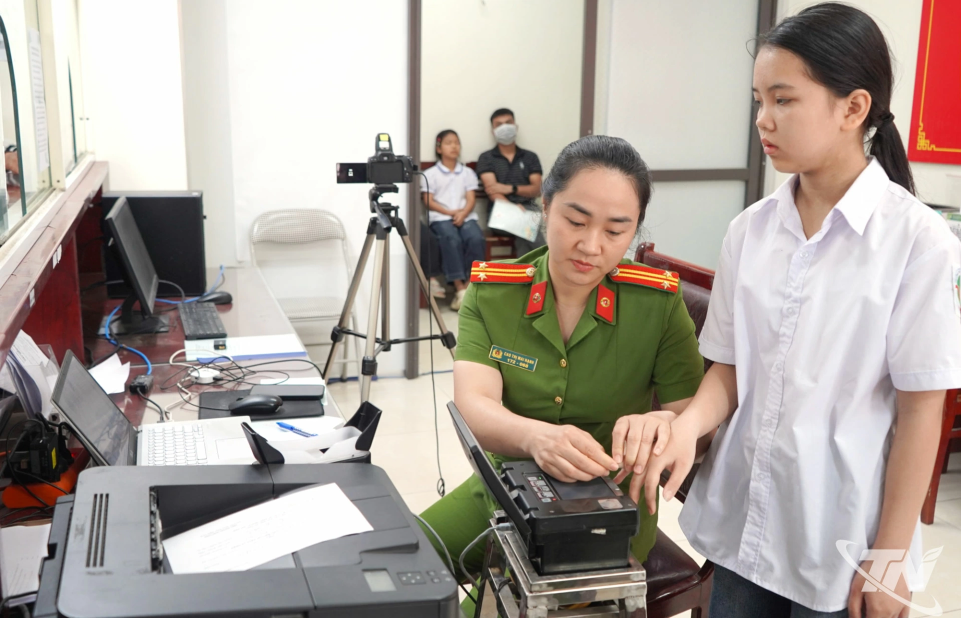 Cán bộ Phòng Cảnh sát QLHC về TTXH hướng dẫn các em học sinh thực hiện thủ tục.