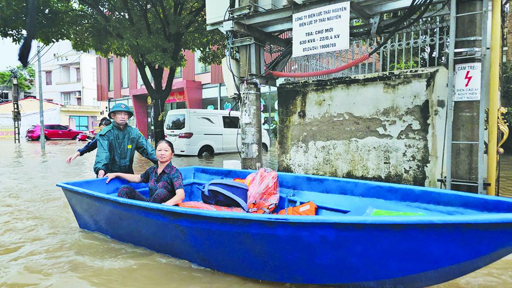 Lực lượng chức năng cứu hộ người dân tại khu vực đường Xuân Hòa (phường Phan Đình Phùng).