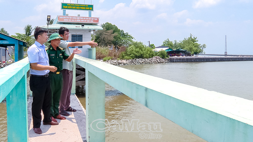 Phó Bí thư Thường trực Ðảng uỷ xã Khánh Lâm Phạm Văn Hiền (bìa trái) khảo sát Cửa biển Khánh Hội.