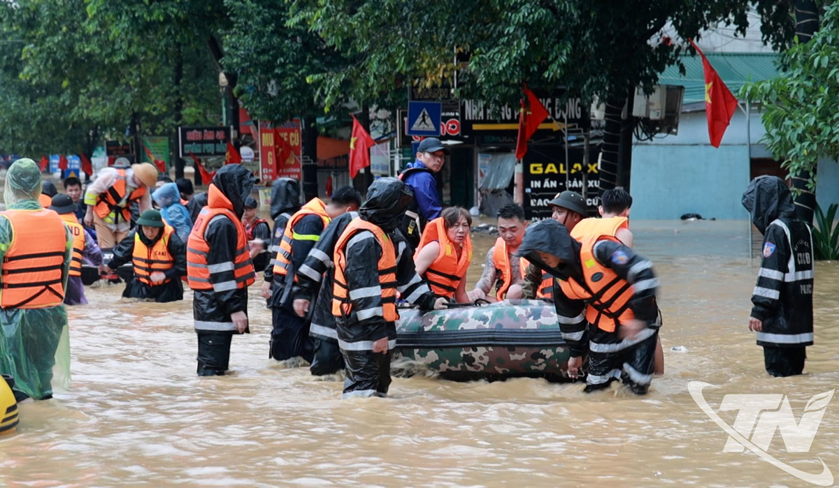 Lực lượng chức năng hỗ trợ người dân di chuyển khỏi khu vực ngập lụt đến nơi an toàn.