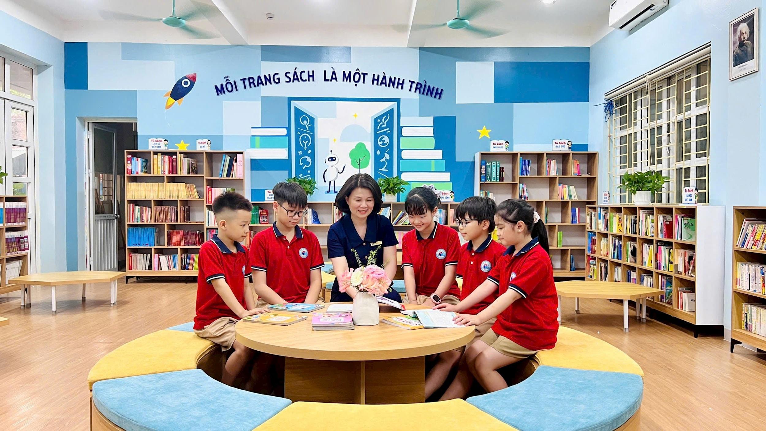 Cô giáo Hoàng Thị Thu Hiền và học sinh tại “Thư viện hiện đại, thân thiện”. Ảnh: