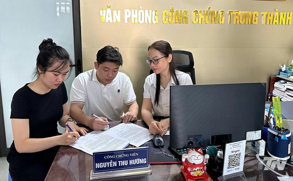 Khách hàng ký kết hợp đồng trước sự chứng kiến của công chứng viên - một bước trong quy trình thực hiện Luật Công chứng 2024.