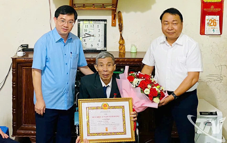 Đồng chí Nguyễn Thành Minh, Chánh Văn phòng Tỉnh ủy trao Huy hiệu 45 tuổi Đảng cho đảng viên Vũ Văn Học.