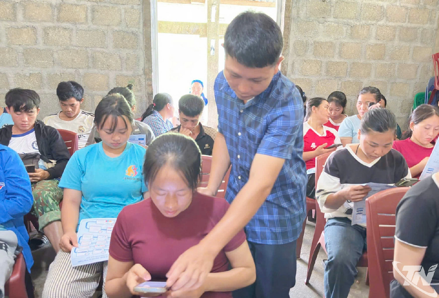 Cán bộ chuyên môn của xã hướng dẫn người dân sử dụng AI trên điện thoại di động.  