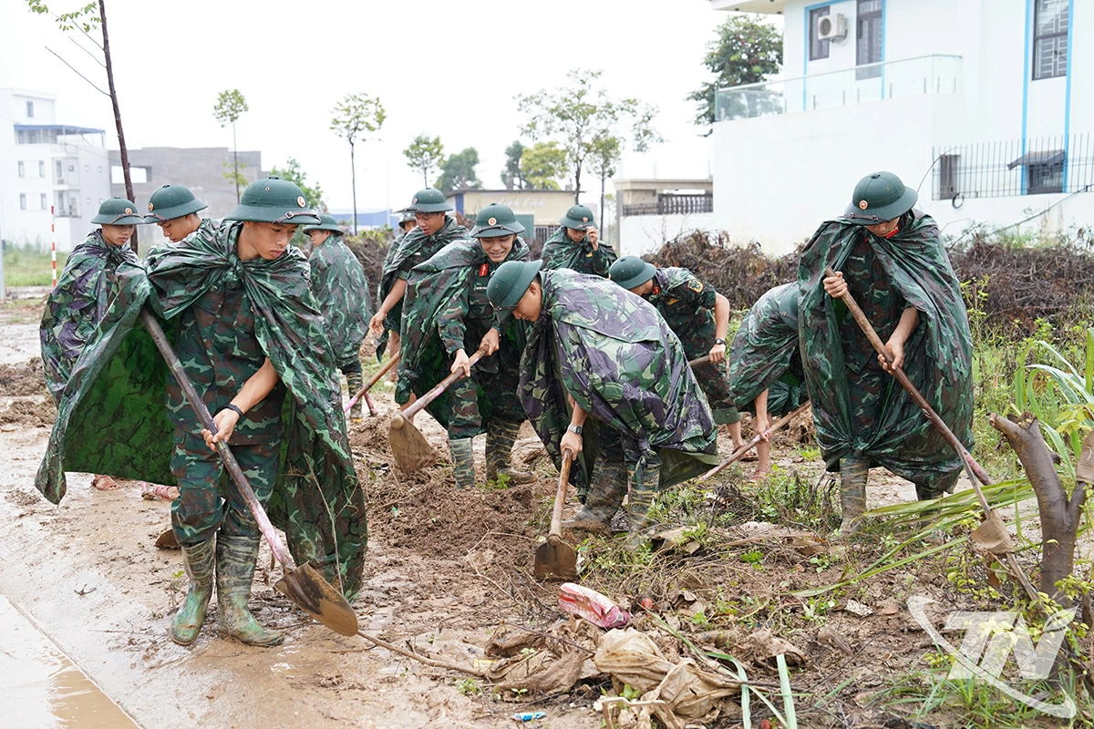 Lực lượng quân đội, công an phối hợp ra quân tổng vệ sinh môi trường, góp phần làm sạch cảnh quan sau mưa bão.