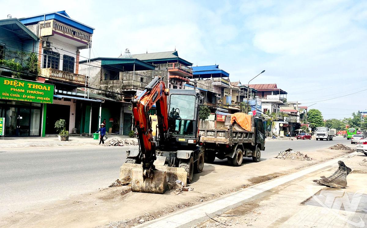 Nhân lực và máy móc được huy động để đẩy nhanh tiến độ thi công vỉa hè trên tuyến Quốc lộ 3 đoạn qua xóm Giang Tiên, xã Phú Lương.