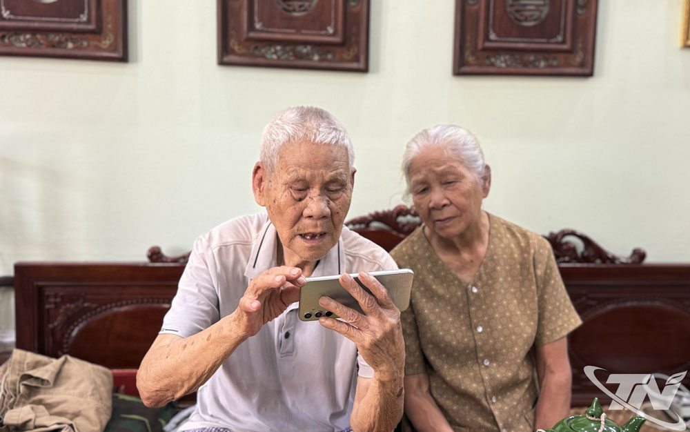 Vợ chồng ông Nguyễn Quân, ở tổ 11A, phường Đức Xuân, theo dõi Kỳ họp qua điện thoại thông minh.