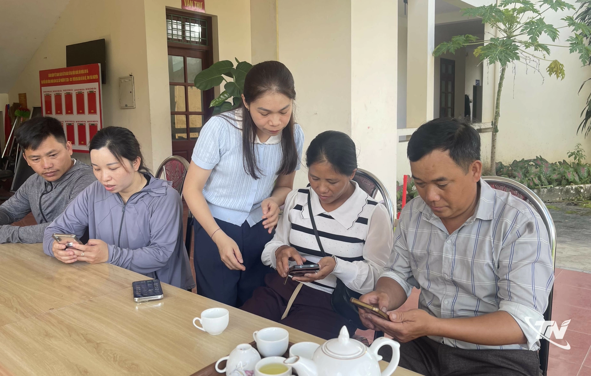 Thành viên Tổ công nghệ số cộng đồng thôn Khang Ninh hỗ trợ người dân cài đặt ứng dụng sô trên điện thoại thông minh.