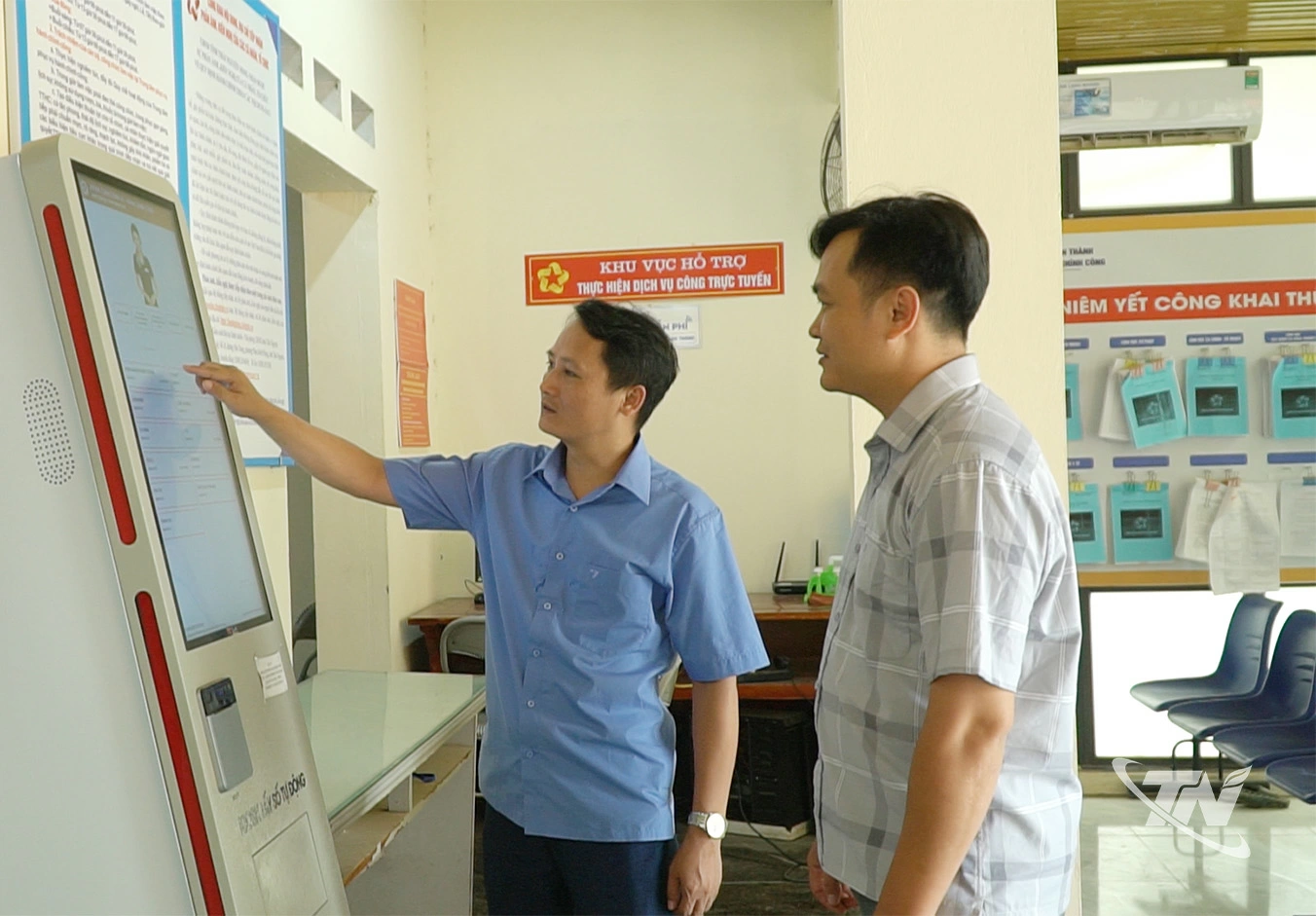 Cán bộ Trung tâm Phục vụ hành chính công xã Tân Thành hướng dẫn người dân lấy số thứ tự trên máy tự động khi thực hiện thủ tục hành chính.