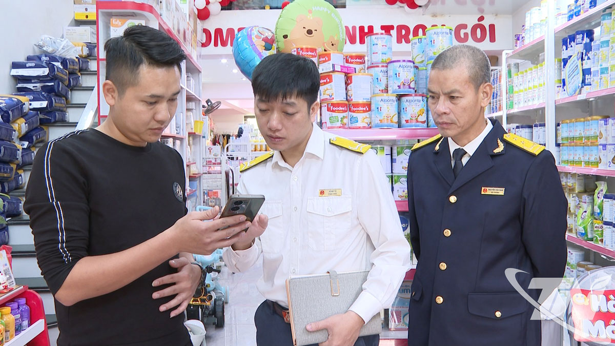 Cán bộ Thuế hướng dẫn người dân nộp thuế điện tử qua thiết bị công nghệ.