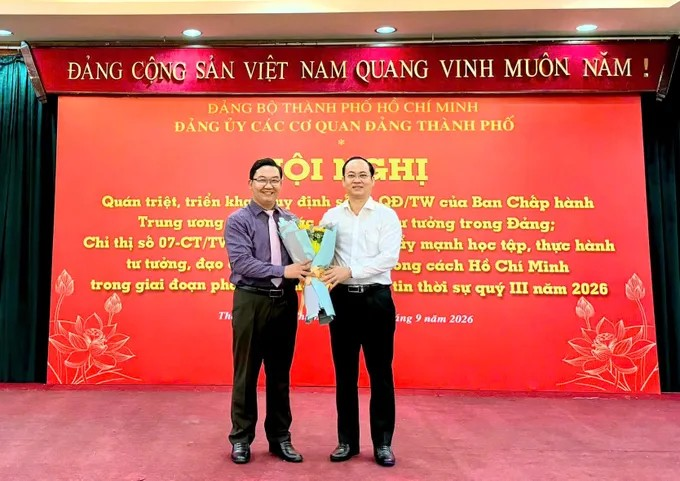Phó Bí thư Đảng ủy các cơ quan Đảng TPHCM Nguyễn Khoa Hải tặng hoa cho báo cáo viên Đặng Văn Khoa. Ảnh: KHÁNH HUY