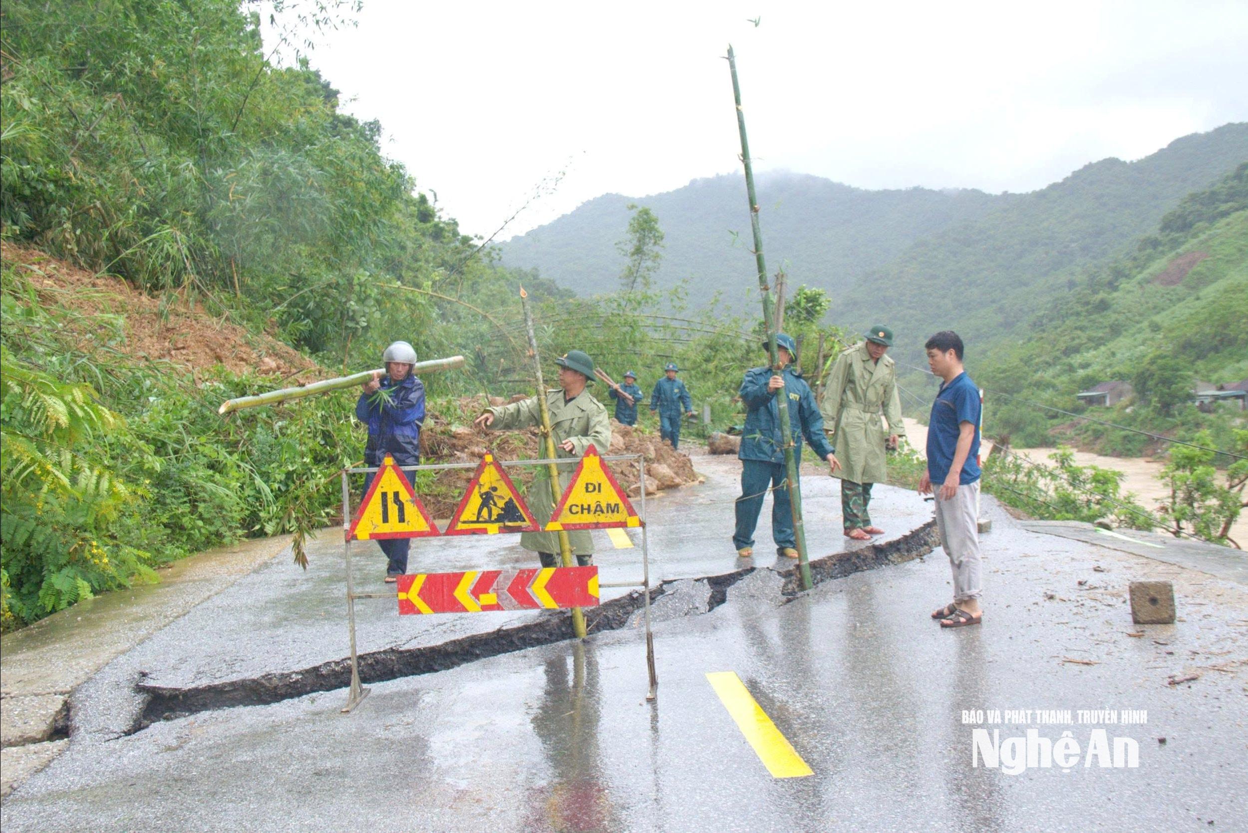 Dân quân xã Tương Dương lập hàng rào cảnh báo các vị trí sạt lở và nguy hiểm trên Quốc lộ 7. Ảnh: Trọng Kiên
