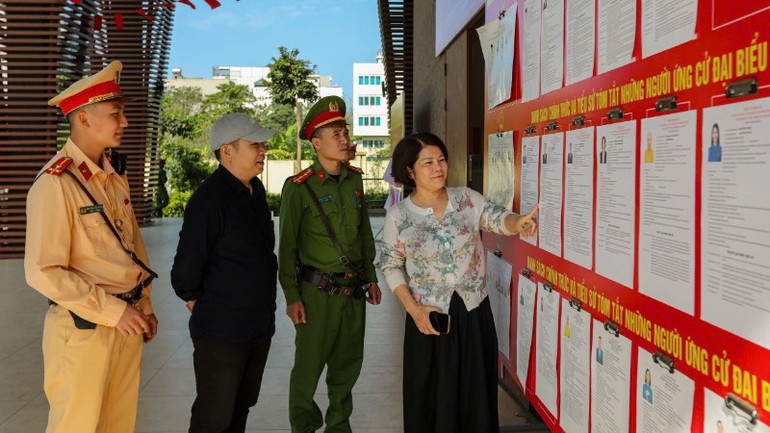 Công an Hà Nội hướng dẫn cử tri rà soát danh sách các đại biểu ứng cử.