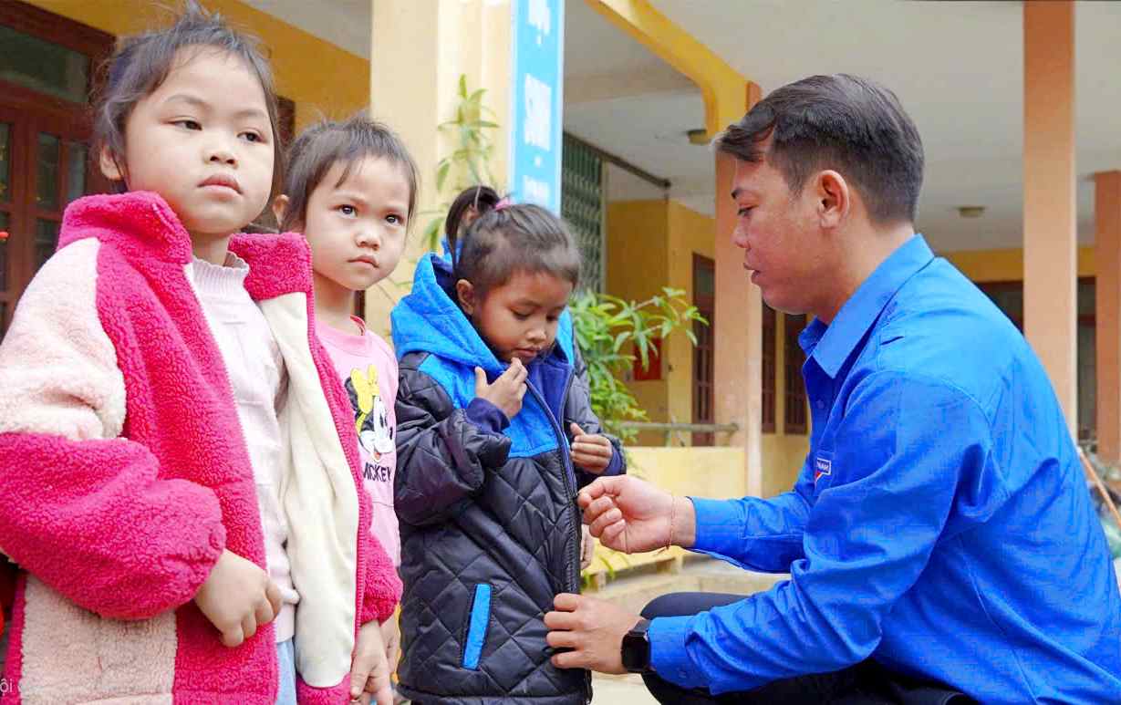 Bí thư Đoàn Thanh niên UBND tỉnh Nguyễn Tuấn Hùng tặng áo ấm cho trẻ em có hoàn cảnh khó khăn           - Ảnh: Q.H
