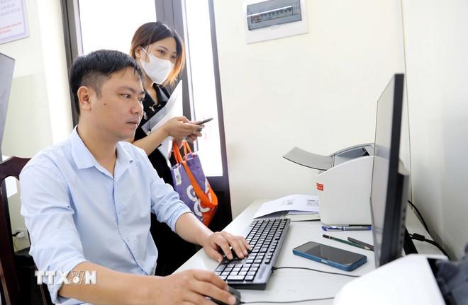 Người dân thực hiện các thủ tục hành chính tại Trung tâm phục vụ hành chính công phường Thái Bình. (Ảnh: Thế Duyệt/TTXVN) ttxvn-0908-hung-yen-chinh-quyen-2-cap-3.jpg
