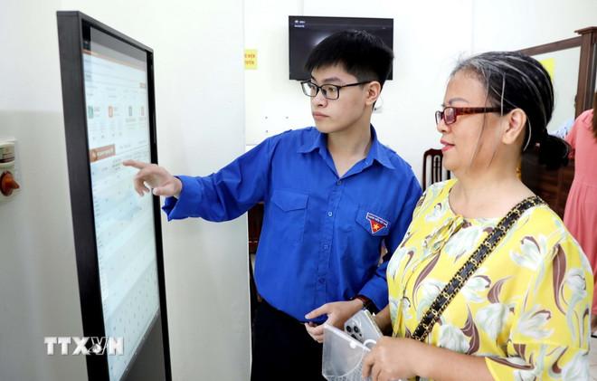 Hướng dẫn người dân thực hiện các thủ tục hành chính tại Trung tâm phục vụ hành chính công phường Thái Bình. (Ảnh: Thế Duyệt/ TTXVN) ttxvn-0908-hung-yen-chinh-quyen-2-cap-2.jpg