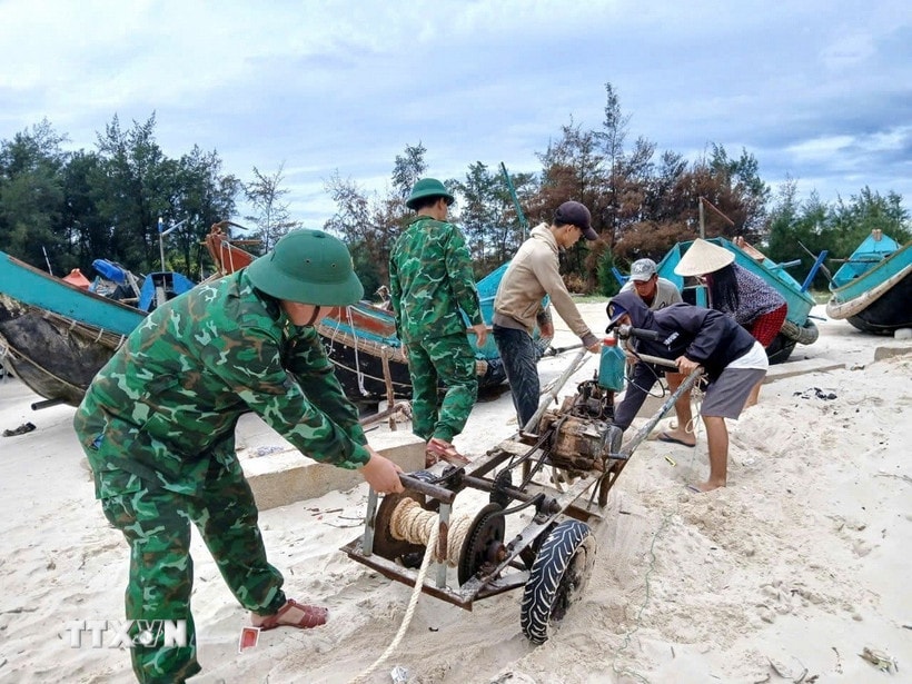 Bộ đội Biên phòng Quảng Trị hỗ trợ ngư dân đưa thuyền neo đậu ở vị trí an toàn, đảm bảo hạn chế thiệt hại do mưa bão gây ra. (Ảnh: TTXVN phát)