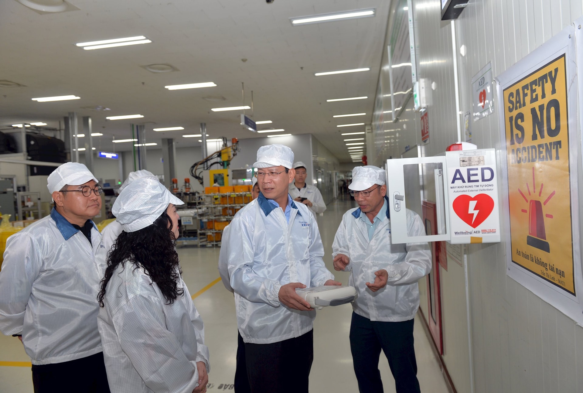 Đồng chí Bùi Đức Quang, Phó chủ tịch Hội đồng nhân dân thành phố và các thành viên trong đoàn tham quan khu vực sản xuất tại công ty TNHH Hyundai Kefico Việt Nam.