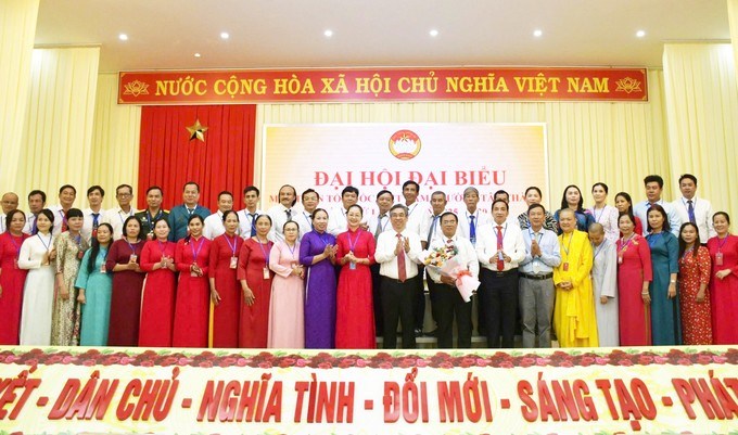 Đồng chí Nguyễn Phước Lộc tặng hoa chúc mừng ủy viên Ủy ban MTTQ Việt Nam phường Tân Thành. (Ảnh: SGGP)