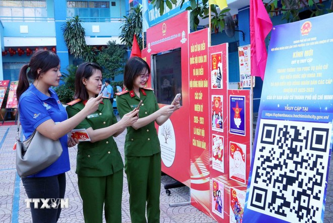 Cử tri trẻ Thành phố Hồ Chí Minh quét mã QR để tham gia cuộc thi tìm hiểu về Luật Bầu cử trực tuyến. (Ảnh: TTXVN)