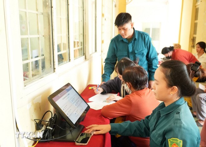 Lực lượng dân phòng ở xã Thái Mỹ, Thành phố Hồ Chí Minh, tham gia hướng dẫn người dân làm thủ tục dịch vụ công trực tuyến. (Ảnh: TTXVN)