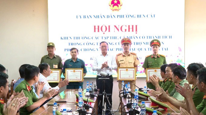 Bí thư Đảng ủy phường Bến Cát Nguyễn Trọng Ân khen thưởng các tập thể có thành tích trong công tác cứu trợ nhân dân. (Ảnh: SGGP)