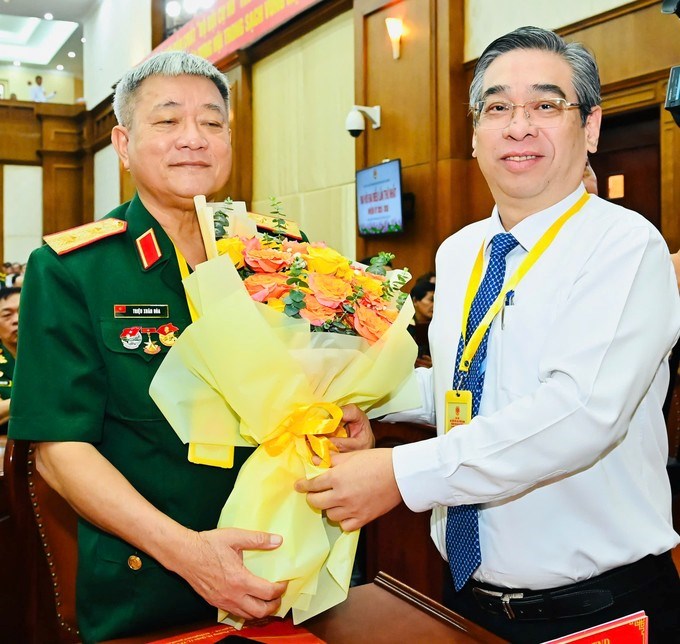 Phó Bí thư Thành ủy TPHCM Nguyễn Phước Lộc tặng hoa Trung tướng Anh hùng LLVT Triệu Xuân Hòa tại Đại hội. (Ảnh: SGGP)