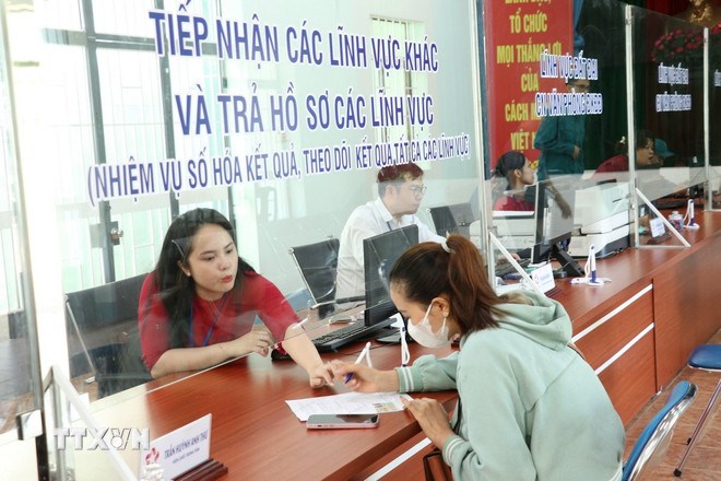 Hướng dẫn người dân làm thủ tục đăng ký hộ kinh doanh. (Ảnh: TTXVN)