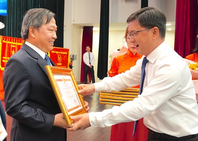 Đồng chí Nguyễn Mạnh Cường trao bằng khen của UBND TPHCM tặng GS.TS Nguyễn Văn Phước. (Ảnh: SGGP)