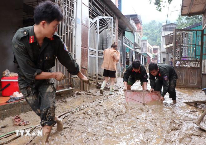 Các chiễn sỹ đồn biên phòng Cửa khẩu Quốc tế Thanh Thủy (Tuyên Quang) giúp người dân dọn vệ sinh sau lũ. (Ảnh: Đức Thọ/TTXVN) ttxvn-bo-doi-bien-phong-2.jpg