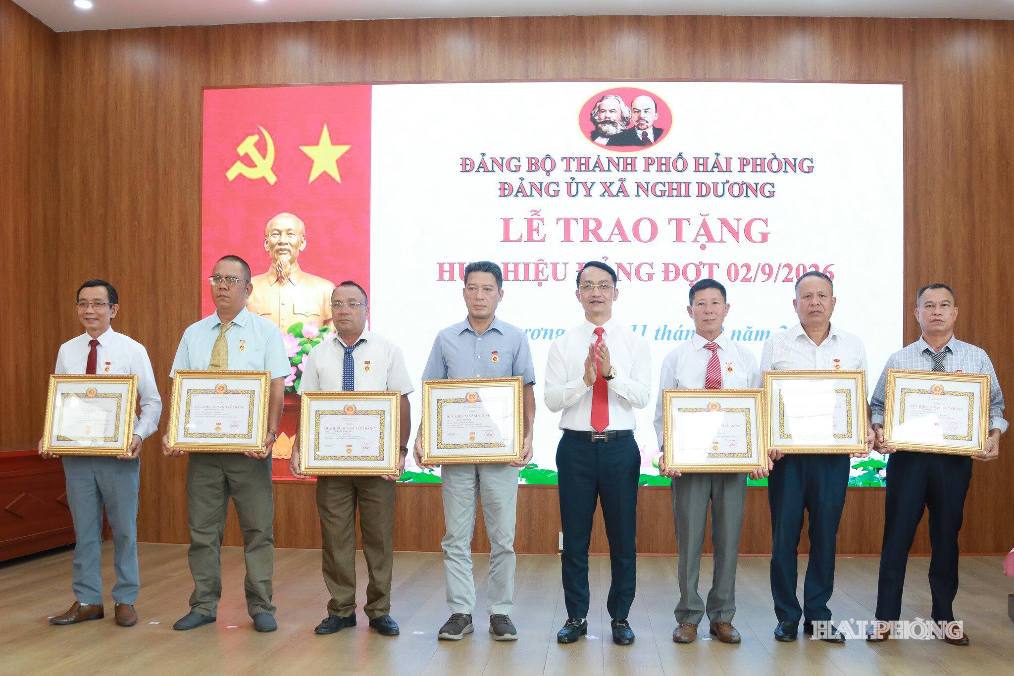 Đại diện lãnh đạo xã trao huy hiệu đảng tặng các đảng viên