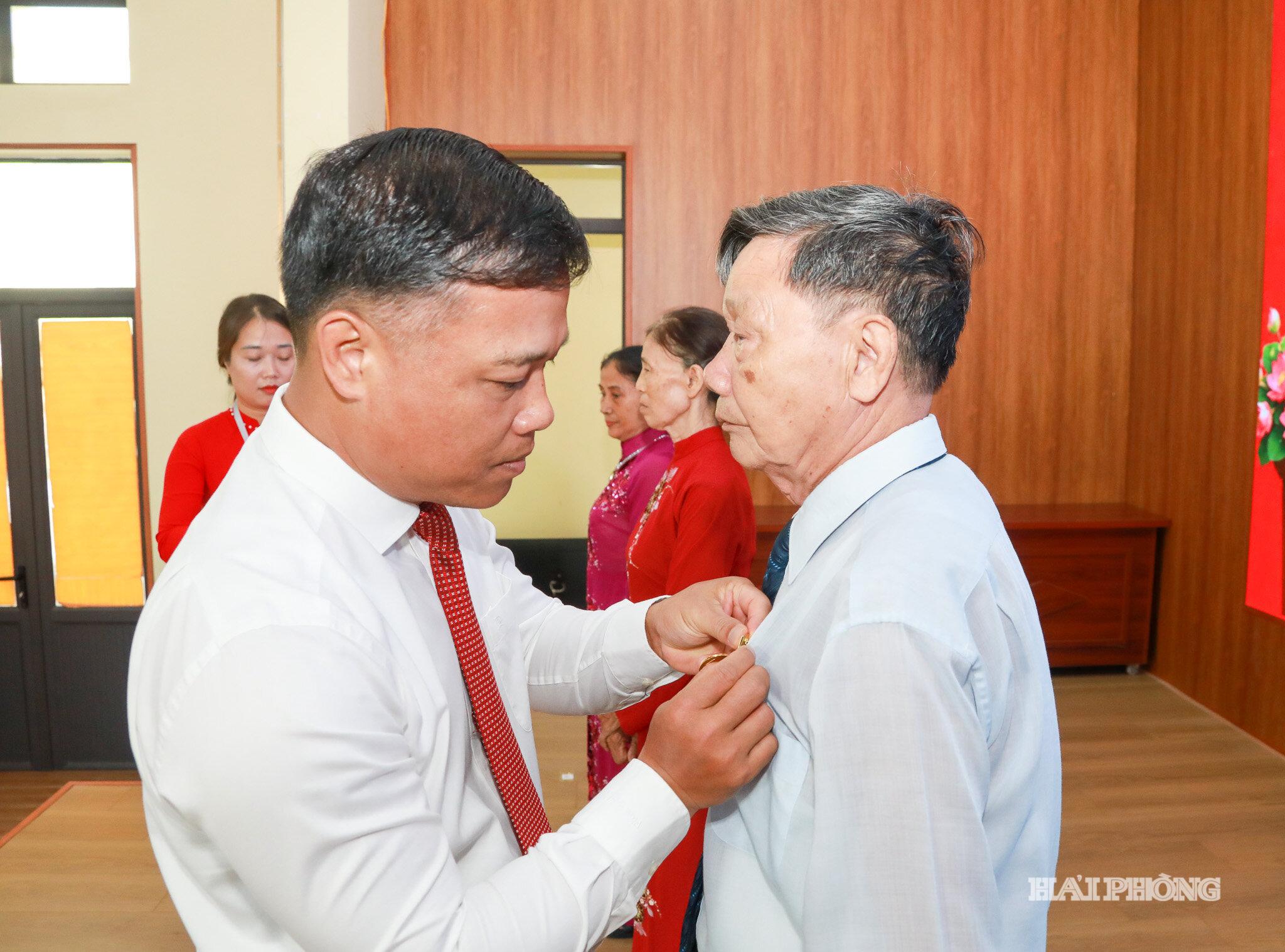 Đồng chí Lương Văn Công, Bí thư Đảng ủy, Chủ tịch HĐND xã trao huy hiệu đảng tặng các đảng viên
