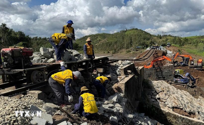 Các công nhân gia cố phần móng đường sắt bị sạt lở do bão số 13 ở xã Xuân Lãnh (tỉnh Đắk Lắk) . (Ảnh: Tường Quân/TTXVN)