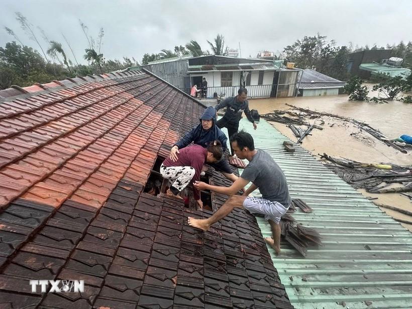 Lũ dâng cao, người dân phải phá mái nhà leo lên để tránh nguy hiểm ở Gia Lai. (Ảnh: TTXVN phát)