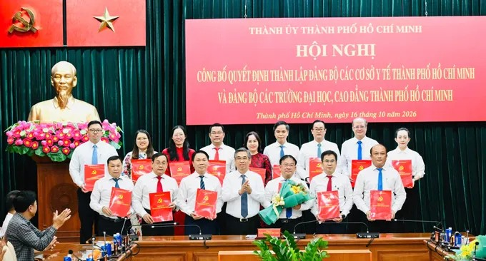 Đồng chí Nguyễn Phước Lộc trao quyết định và tặng hoa chúc mừng Ban Chấp hành Đảng bộ các cơ sở y tế TPHCM. Ảnh: VIỆT DŨNG