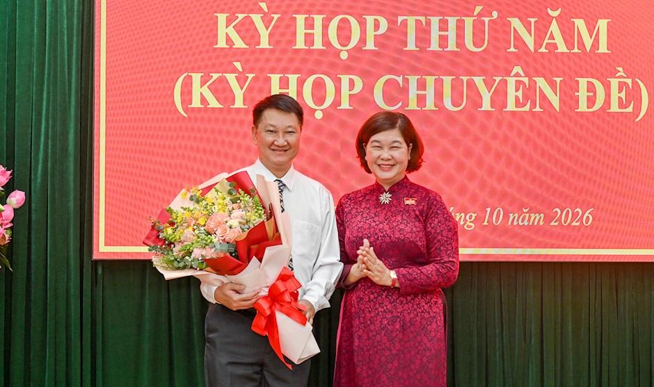 Đồng chí Hoàng Thị Tố Nga, Bí thư Đảng ủy, Chủ tịch HĐND phường Bến Thành, tặng hoa chúc mừng đồng chí Nguyễn Ngọc Văn