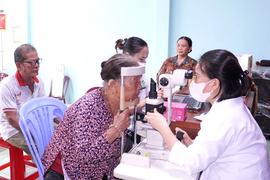 Các y, bác sĩ kiểm tra thị lực cho người cao tuổi tại thôn Mỹ Đồng.