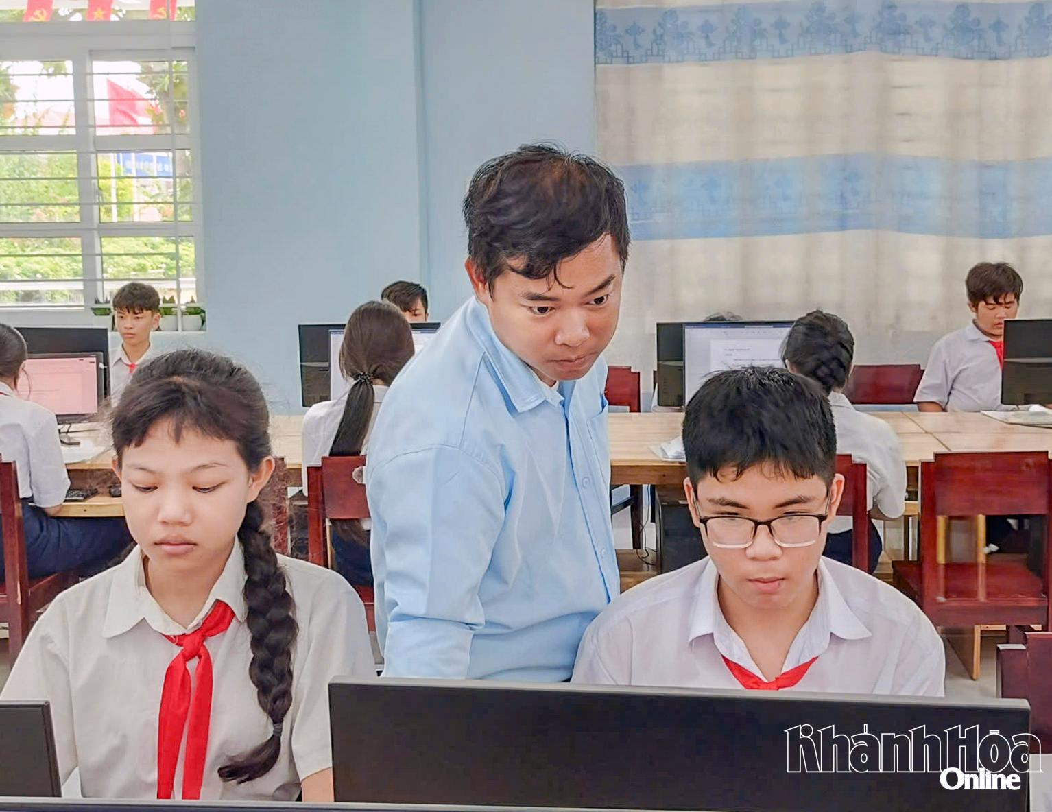 Anh Phạm Thanh Mân   hướng dẫn học sinh trong giờ học Tin học.