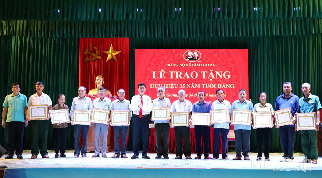 Đồng chí Phó Chủ nhiệm Thường trực Ủy ban Kiểm tra Tỉnh ủy Trần Văn Giang và lãnh đạo Đảng ủy xã Bình Giang trao tặng Huy hiệu 35 năm tuổi Đảng cho các đảng viên. Ảnh: Nguyễn Oanh