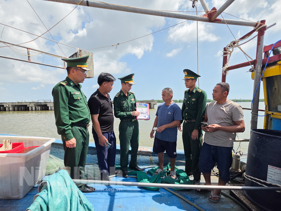 Cán bộ, chiến sĩ Đồn Biên phòng Kim Sơn tuyên truyền ngư dân cập nhật tình hình thời tiết trên biển.