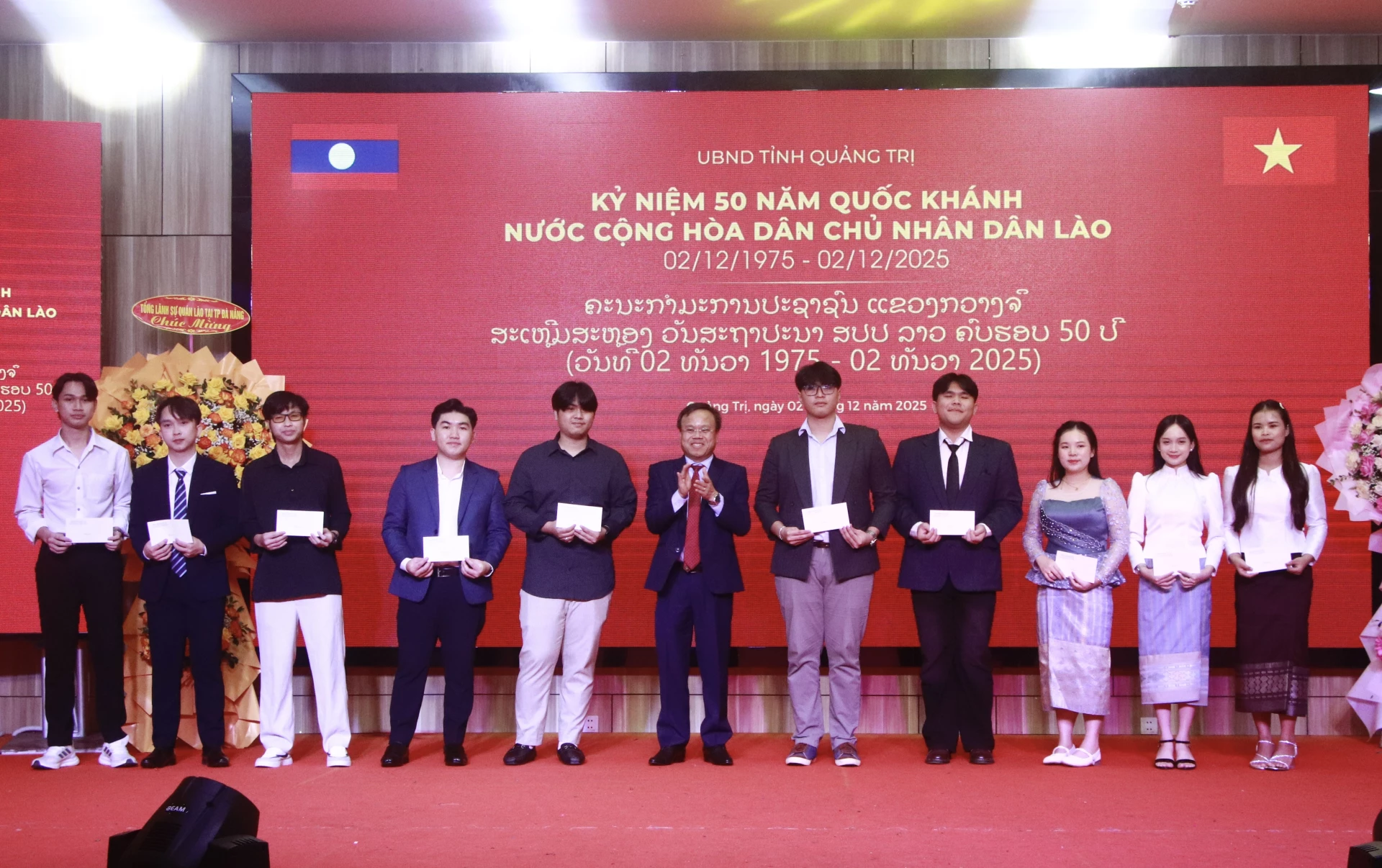 Phó Chủ tịch UBND tỉnh Lê Đức Tiến trao quà cho lưu học sinh Lào - Ảnh: H.N